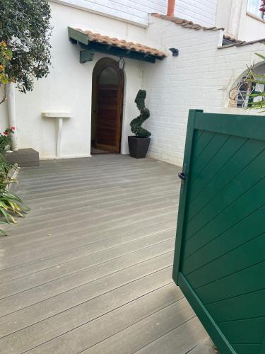 un portail vert devant une maison avec une porte dans l'établissement L'Eden, à Arcachon