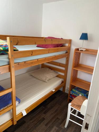 une chambre avec deux lits superposés et une lampe dans l'établissement L'Eden, à Arcachon