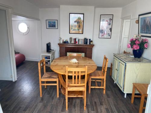 une salle à manger avec une table et des chaises en bois dans l'établissement L'Eden, à Arcachon