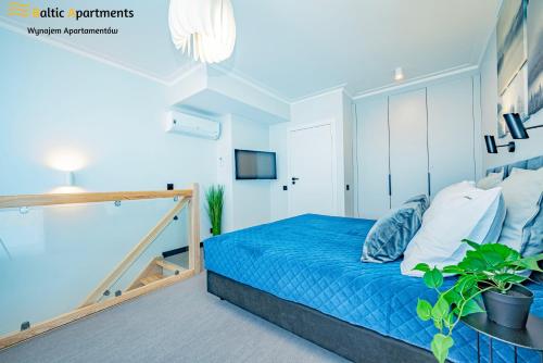 a bedroom with a blue bed and a tv at Baltic Apartments - Albus in Świnoujście