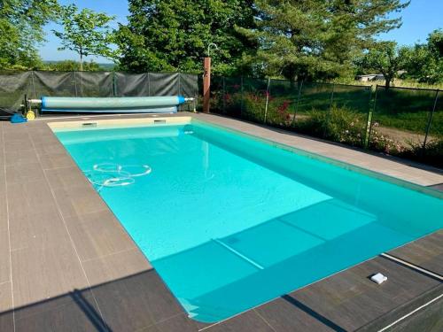 - une piscine avec une piscine bleue dans l'établissement L'Arche familiale - Charmante maison à la campagne, à La Dornac