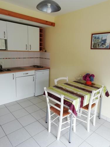 - une cuisine avec une table, des chaises et une table dans l'établissement DOUARNENEZ Tréboul près des plages, à Douarnenez