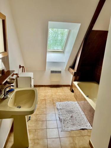 une salle de bain avec un lavabo et une baignoire dans l'établissement L'Arche familiale - Charmante maison à la campagne, à La Dornac