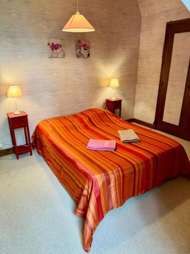 - une chambre avec un lit avec deux lampes et deux tables dans l'établissement L'Arche familiale - Charmante maison à la campagne, à La Dornac