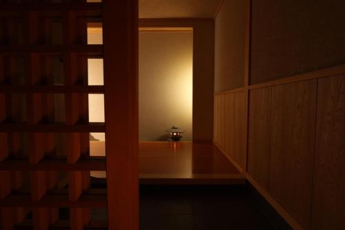 a room with a door open to a room with a lamp at Awanoyu in Matsumoto