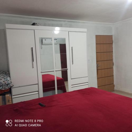 a bedroom with a red bed and a mirror at flet para temporadas in Petrolina