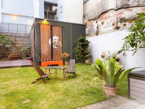 a garden with two chairs and a table in the grass at Sleep jia in Tainan