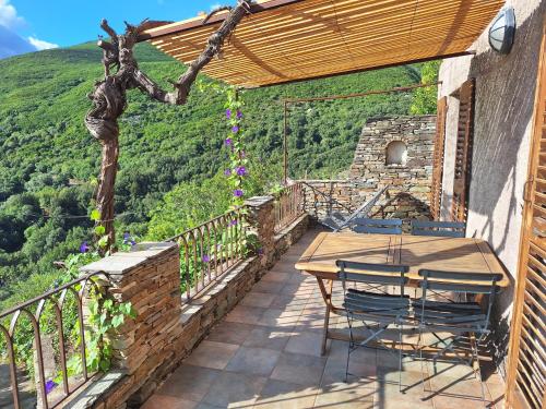 un patio avec une table et des chaises sur un balcon dans l'établissement Maison de village avec terrasse, à Brando