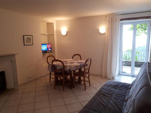 une salle à manger avec une table et des chaises et une fenêtre dans l'établissement Maison de village avec terrasse, à Brando
