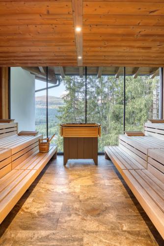 a large room with wooden benches and a large window at Ursprung Panorama Hotel Königsleiten in Königsleiten