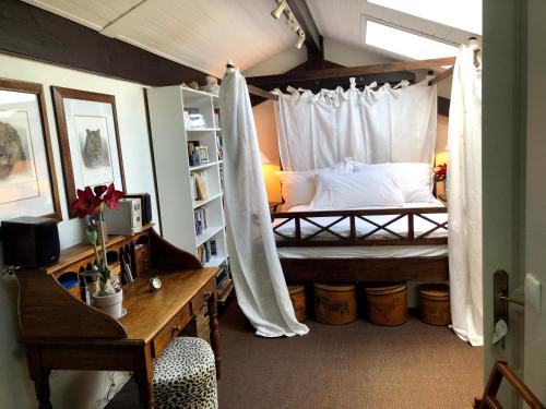 une chambre avec un lit avec moustiquaire dans l'établissement L'arbre aux papillons, à Veigy-Foncenex