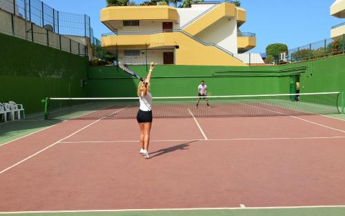 two people playing tennis on a tennis court at HOVIMA Santa María in Adeje