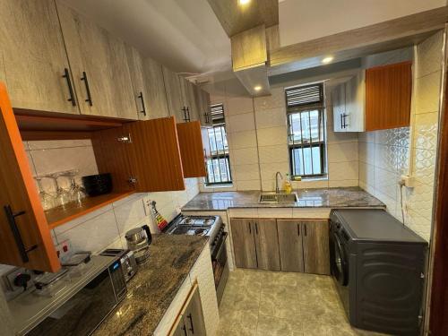 a kitchen with wooden cabinets and a stove top oven at Luxe Loft in Kampala