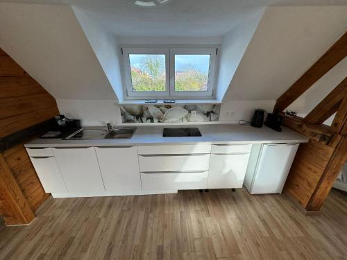 a kitchen with white cabinets and a window at Relaxing in Flachslanden