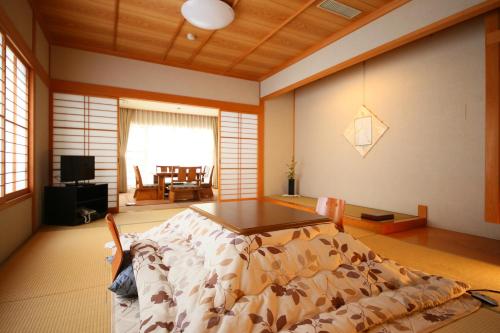 a living room with a bed and a table at Awanoyu in Matsumoto