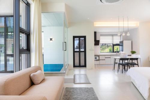 un salon avec un canapé et une salle à manger dans l'établissement Gangneung Ranteuruhe Pension, à Gangneung