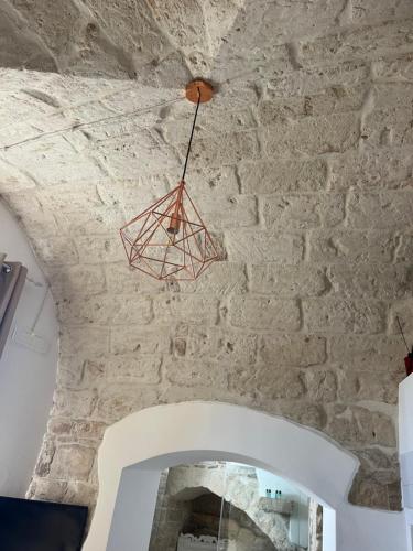 a chandelier hanging from the ceiling of a stone wall at La Fiumara - Room with Bathroom in Bitonto
