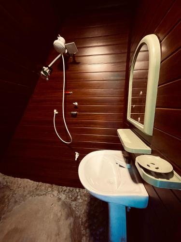 a bathroom with a sink and a mirror at Devilmountain kabana Kalupahana in Bandarawela