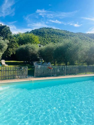 a swimming pool with a fence and a mountain in the background at Agriturismo Le Pozze in Dicomano
