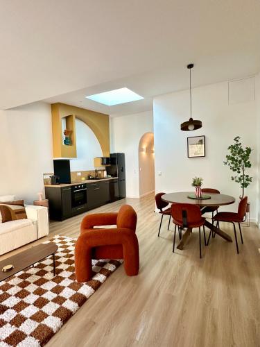 un salon avec un canapé, une table et des chaises dans l'établissement Escapade Chic & Confort - Terrasse - 5 min Gare, à Amiens