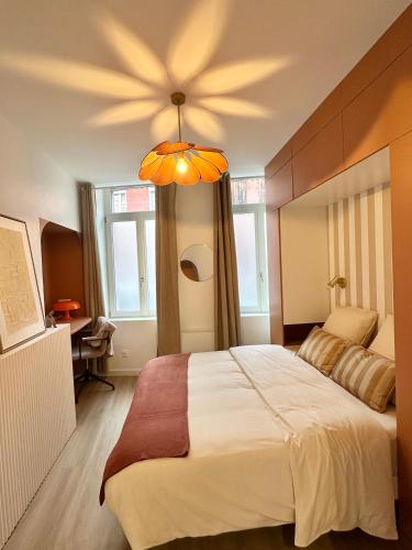 une chambre avec un grand lit et un lustre dans l'établissement Escapade Chic & Confort - Terrasse - 5 min Gare, à Amiens