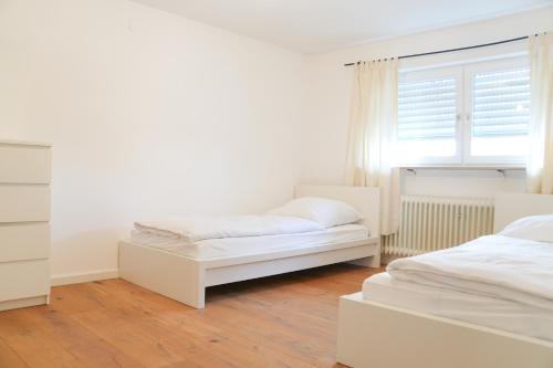 Un dormitorio blanco con dos camas y una ventana. en Stylish Country House Happiness, en Geislingen