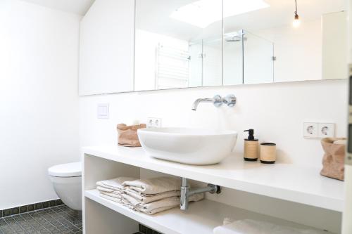 Un baño blanco con lavabo e inodoro. en Stylish Country House Happiness, en Geislingen