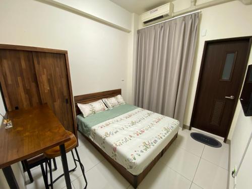 a small bedroom with a bed and a desk at 欣欣台南南科商旅會館 in Ta-ying