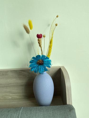 a white vase with flowers in it on a shelf at 欣欣台南南科商旅會館 in Ta-ying