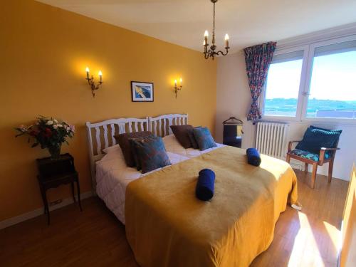 une chambre avec un grand lit avec des oreillers bleus dans l'établissement La Casa Sylvia, 6 pers WIFI, à Boulogne-sur-Mer