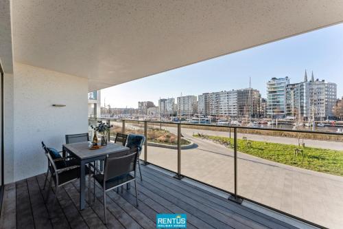 a balcony with a table and chairs and a view of a city at Harbour Feeling - luxury apartment at the Ostend Yacht Harbour in Ostend