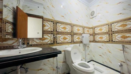 a bathroom with a toilet and a sink at Hotel New Mid City Multan in Multan