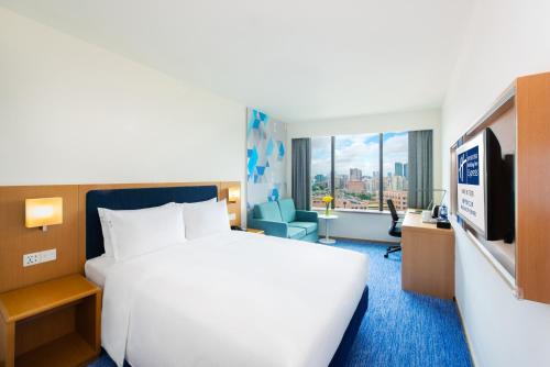 a hotel room with a large bed and a television at Holiday Inn Express Macau City Centre by IHG in Macau
