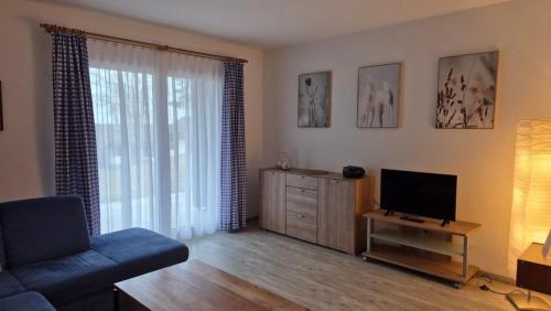 un salon avec un canapé et une télévision dans l'établissement Ferienhaus Nr 91, Kategorie Komfort, Feriendorf Hochbergle, Allgäu, à Karlsebene