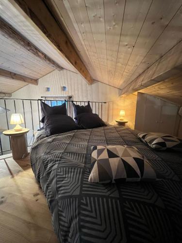 - une chambre avec un lit noir et blanc et des oreillers dans l'établissement La chambre du cantou, à Lautrec