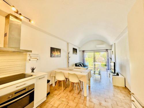 une cuisine et une salle à manger avec une table et des chaises dans l'établissement Le Velusine 2077 - Apt 4 Prs - parking - climatisation - piscine, à Antibes