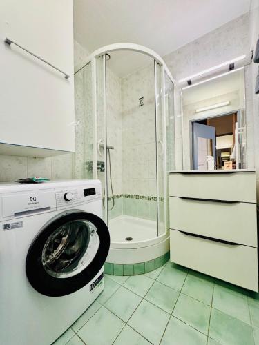une machine à laver dans une salle de bain avec douche dans l'établissement Le Velusine 2077 - Apt 4 Prs - parking - climatisation - piscine, à Antibes