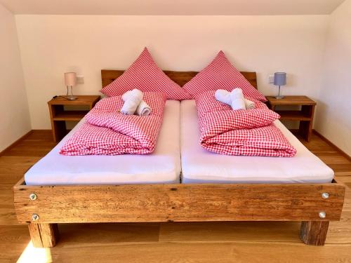 a bedroom with two beds with red and white pillows at BERGFEX Jägersberg mit Sommer-Bergbahnticket in Oberstdorf