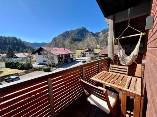 a wooden deck with a hammock and a table and chairs at BERGFEX Jägersberg mit Sommer-Bergbahnticket in Oberstdorf