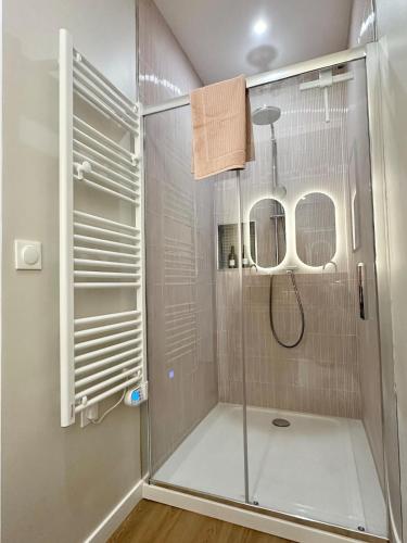 une douche avec une porte vitrée dans une salle de bain dans l'établissement Escapade Chic & Confort - Terrasse - 5 min Gare, à Amiens