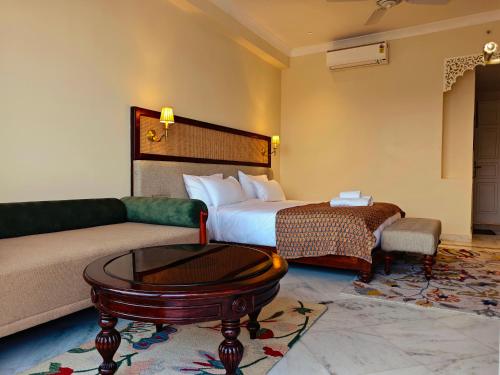 a hotel room with a bed and a couch at Gauri Gangaa in Haridwār