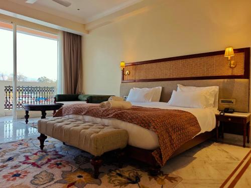 a hotel room with a bed and a large window at Gauri Gangaa in Haridwār