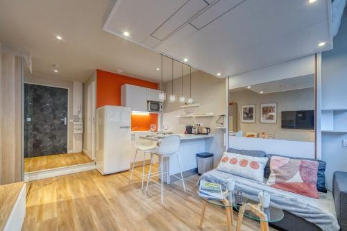 un salon avec un canapé bleu et une cuisine dans l'établissement R'Apparts Luxury Studio 8, à Grenoble