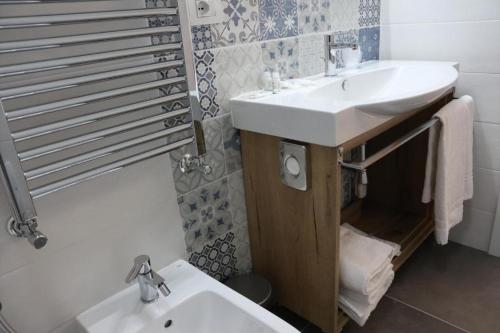 a bathroom with a white sink and a toilet at Residenza La Reggia in Caserta