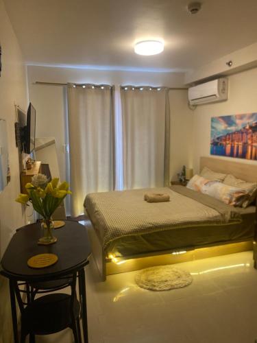 a bedroom with a bed and a table with a vase at Saekyung Marigondon Phase 3 in Suba