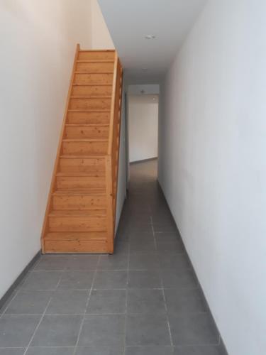 - un couloir avec un escalier en bois dans l'établissement Chambre a louer a Nogaro, à Nogaro