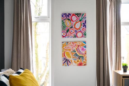 a room with two paintings on the wall next to a window at Stylish Interior Designed Home in Crewe