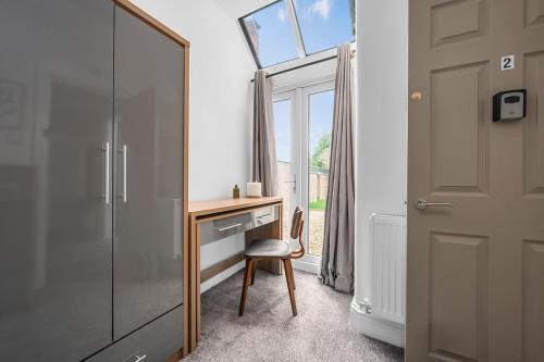 a room with a desk with a mirror and a window at Stylish Interior Designed Home in Crewe
