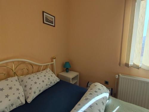 a bedroom with a bed with a blue blanket and pillows at Sun and river Apartments in Golubac