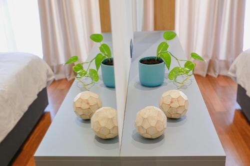 a table with four plants in balls on it at Ciao Xanthi Central Square Studio in Xanthi